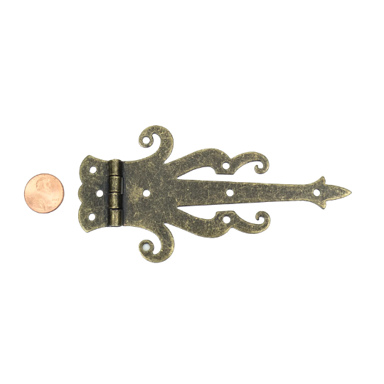 Bronze decorative strap hinge with scrollwork, isolated with coin for scale