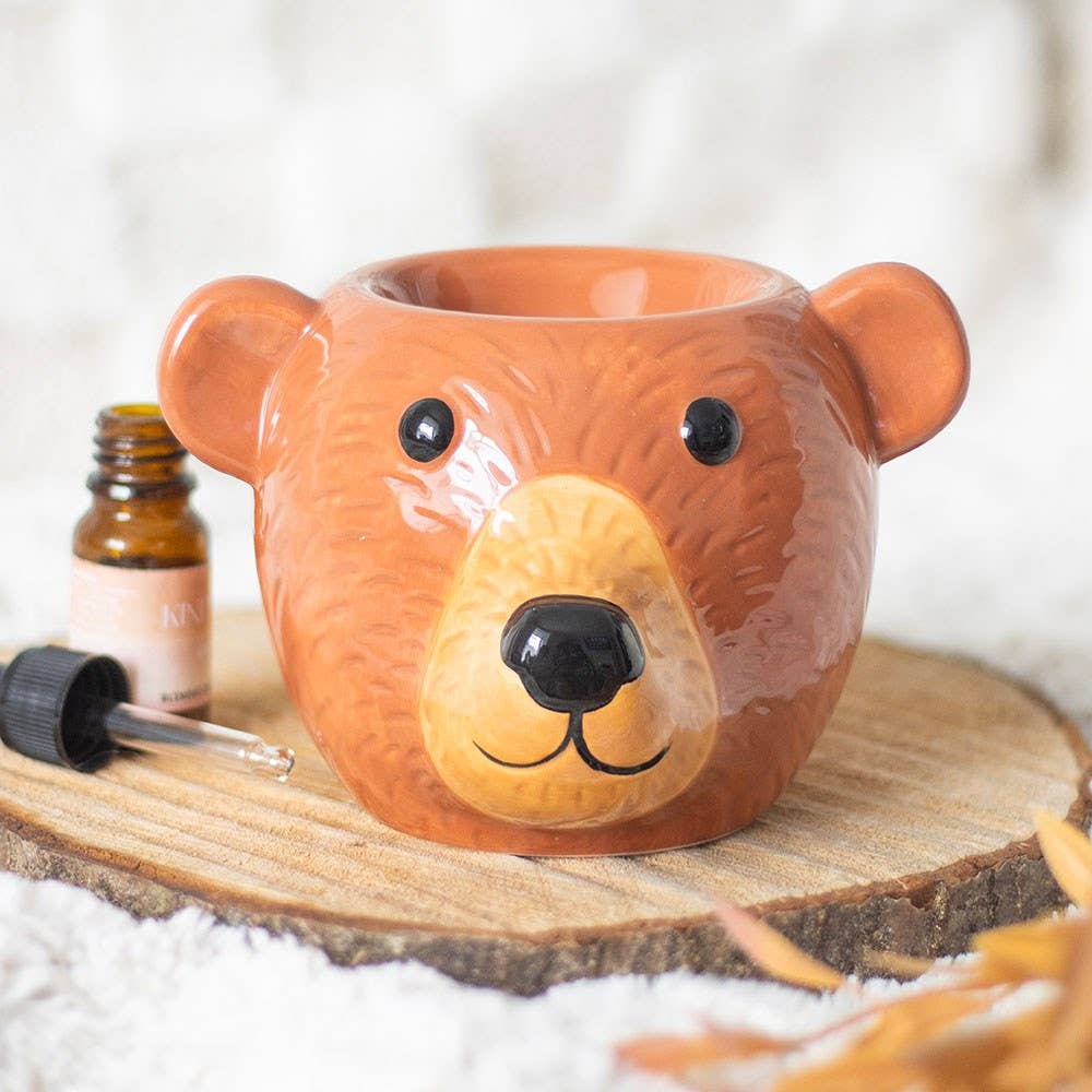 Bear-shaped ceramic oil burner with bear face, orange body, dark eyes, open top
