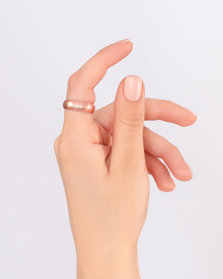 Copper domed ring on finger on an open hand gesture
