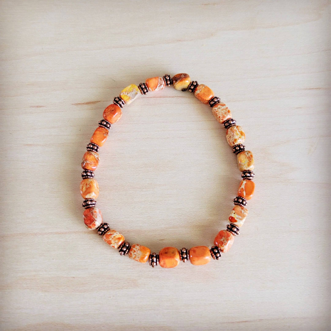 Orange and cream stone-look stretch beaded bracelet with dark spacer beads