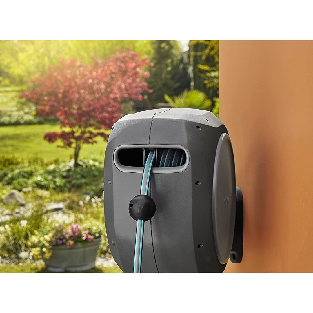Gray GARDENA hose reel housing with front inlet and blue hose leading to wall