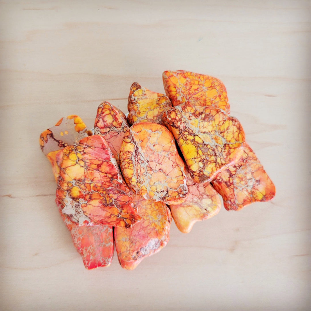 Orange Regalite stone slab pieces for belt buckle, mixed cuts and shapes