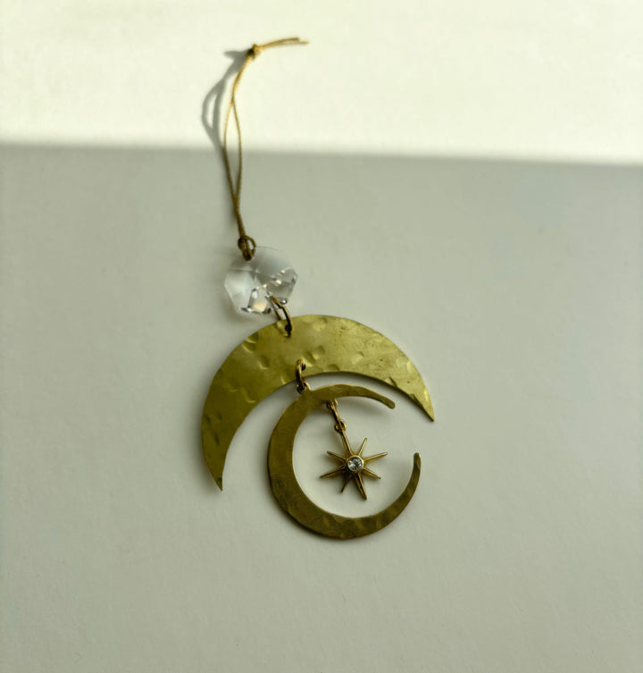 Gold crescent moon ornament with clear crystal bead and star drop, shown from side