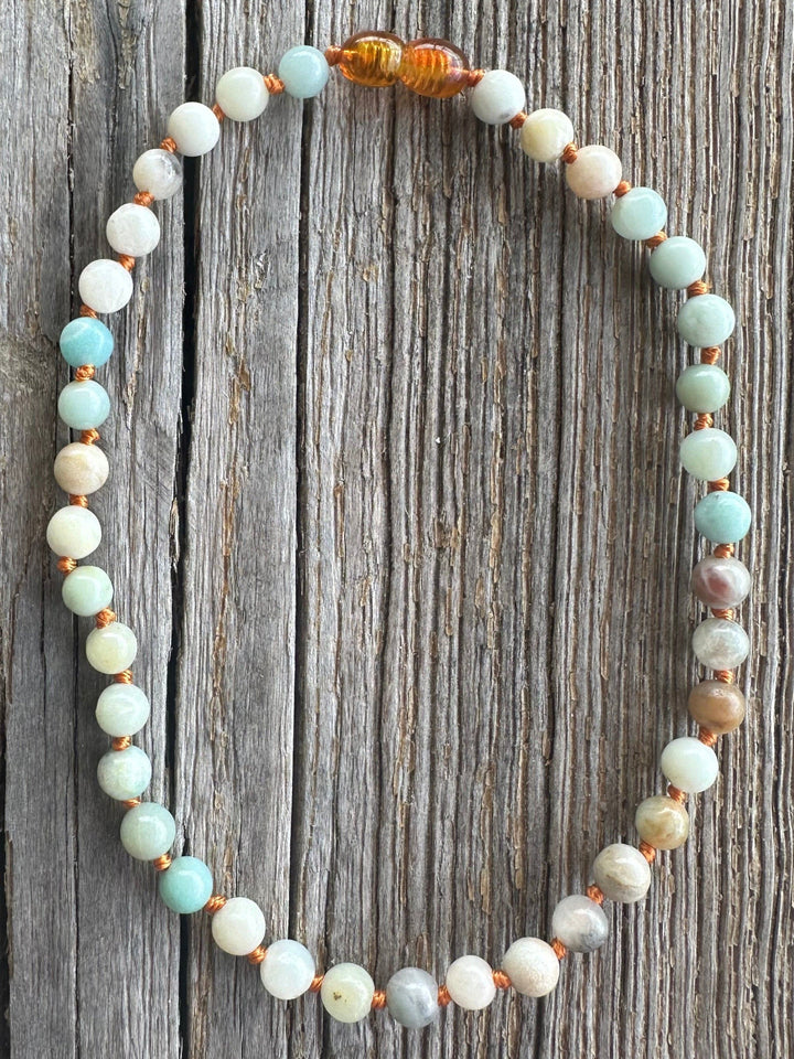 Round beaded necklace with white, aqua, peach, and brown spacer beads.