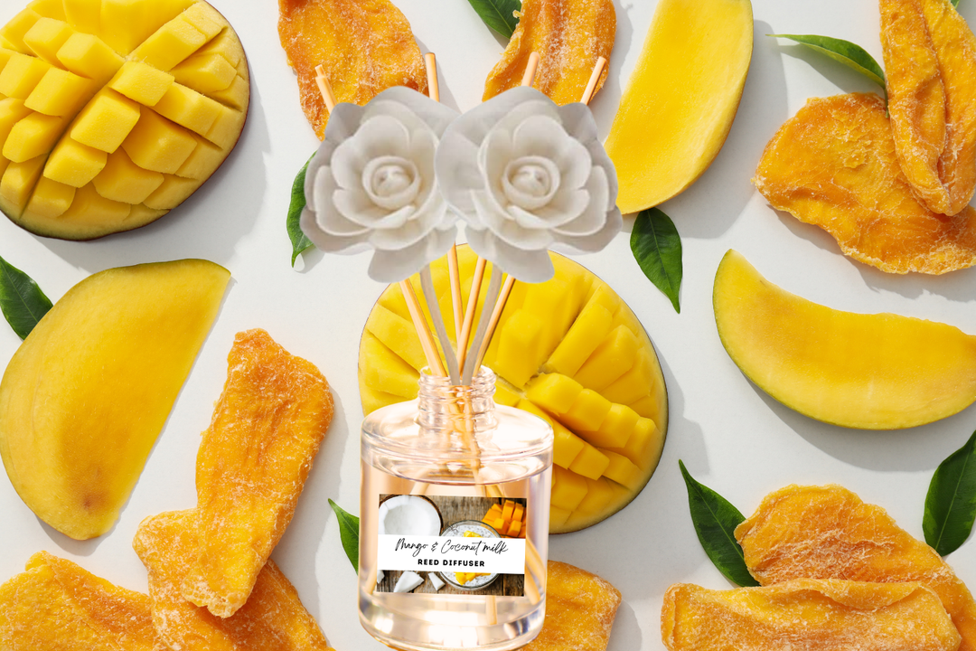 Clear reed diffuser jar with rose-tipped reeds surrounded by mango slices
