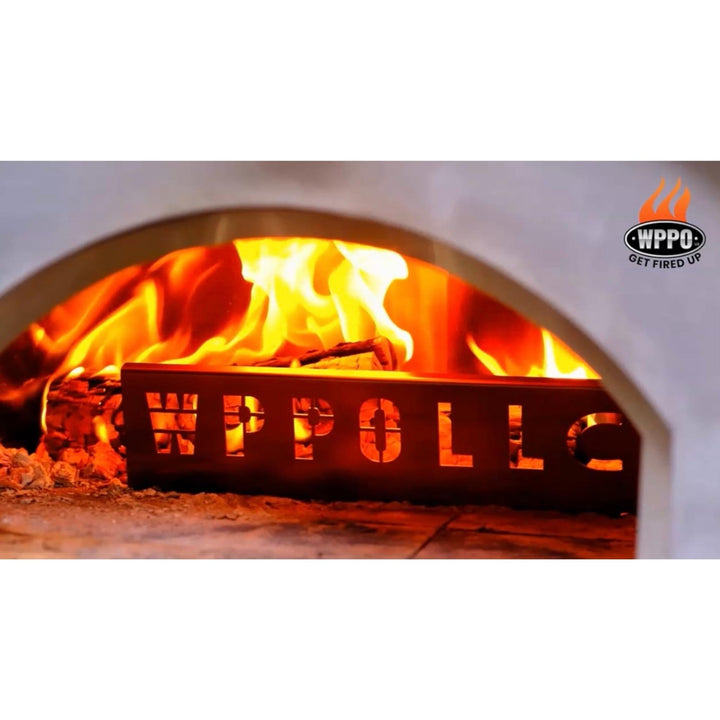 Flame heat deflector in wood-fired oven, engraved front visible above coals