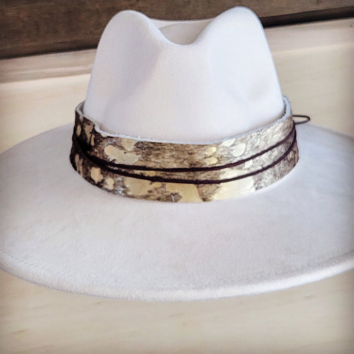 White wide-brim felt hat with brown patterned metallic hat band and lace ties
