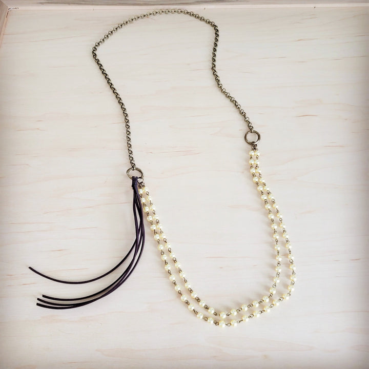 Champagne pearl beaded double-strand necklace with black leather tassel and gold-tone chain.