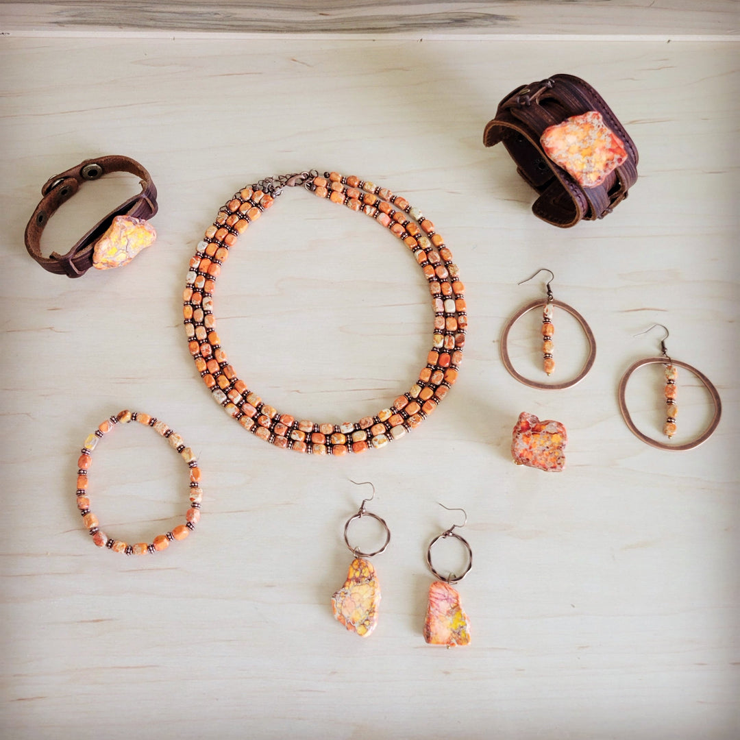 Coiled triple strand beaded necklace with orange and cream beads and bronze chain