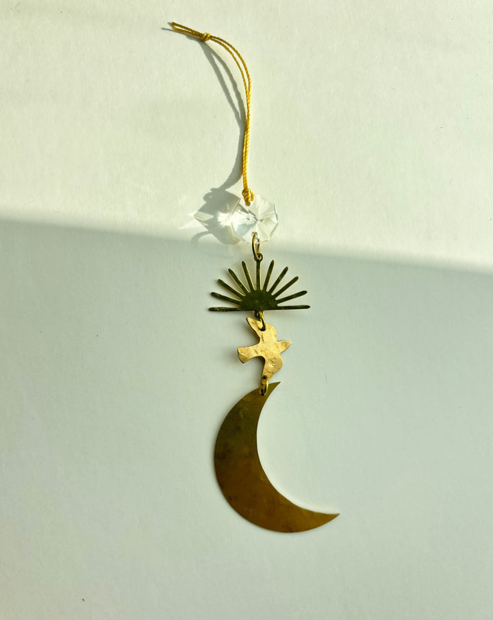 Hanging gold crescent moon ornament with winged figure and starburst charm, looped top