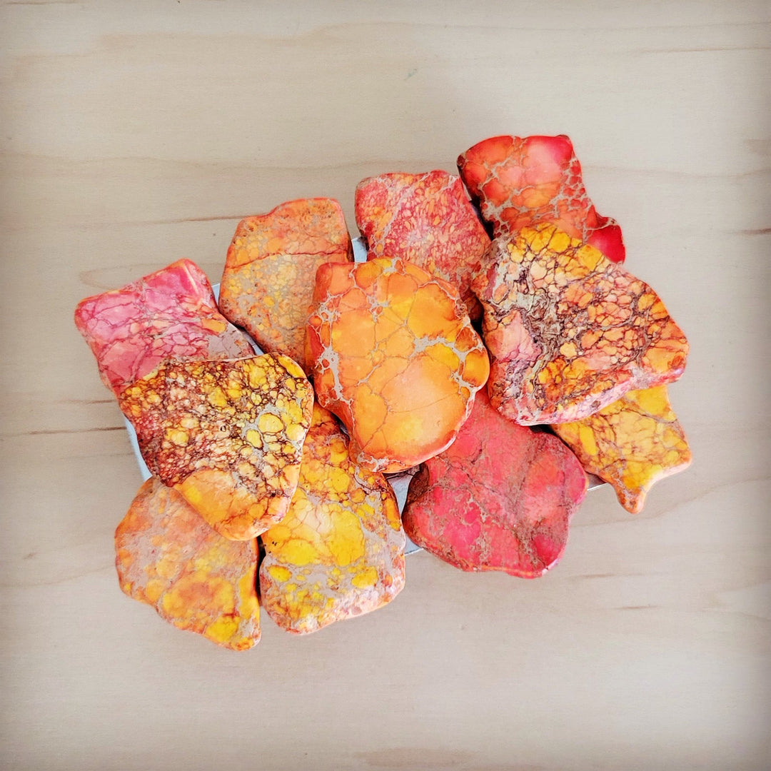 Orange regalite slab belt buckle with stacked multicolor stone petals, decorative centerpiece