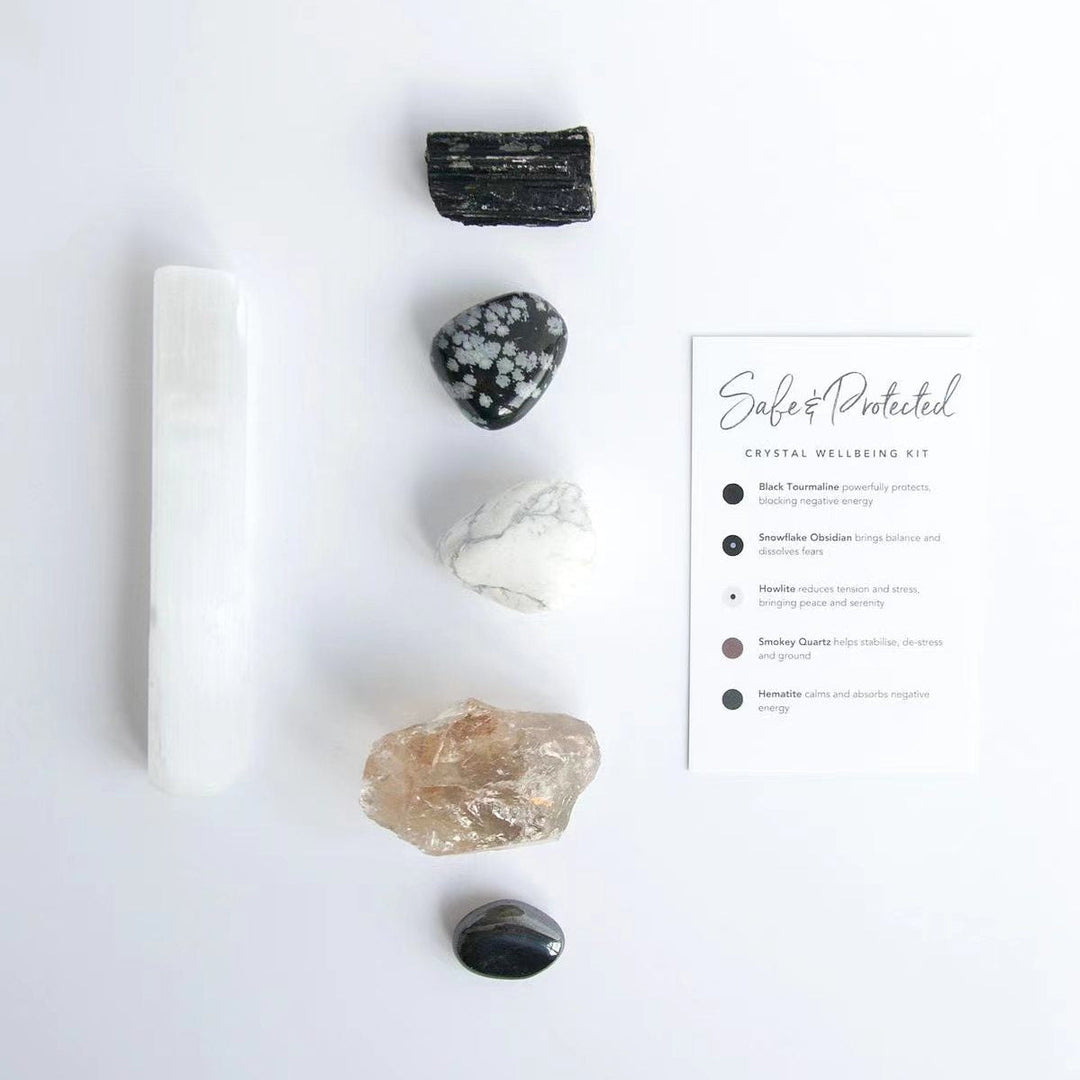 Crystal healing kit with white selenite wand, black and clear stones, plus instructions card.