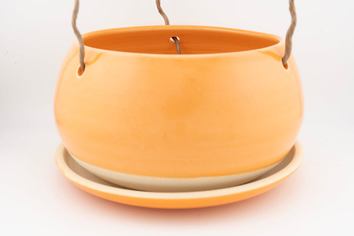 Glazed hanging planter with rope handles and round saucer base, bright orange