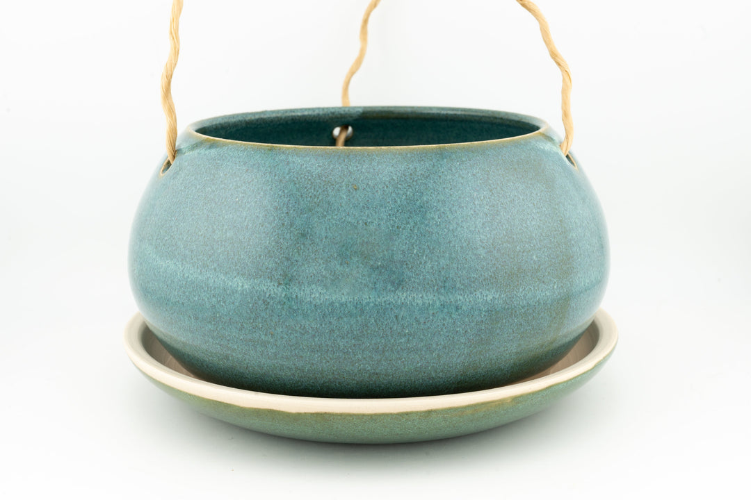 Glazed hanging planter with rope handles and round saucer base, muted teal