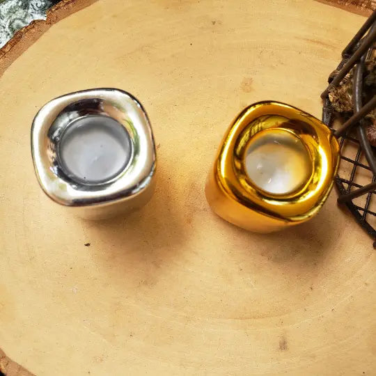 Ceramic candle holders with silver and gold metal-rim openings on beige base