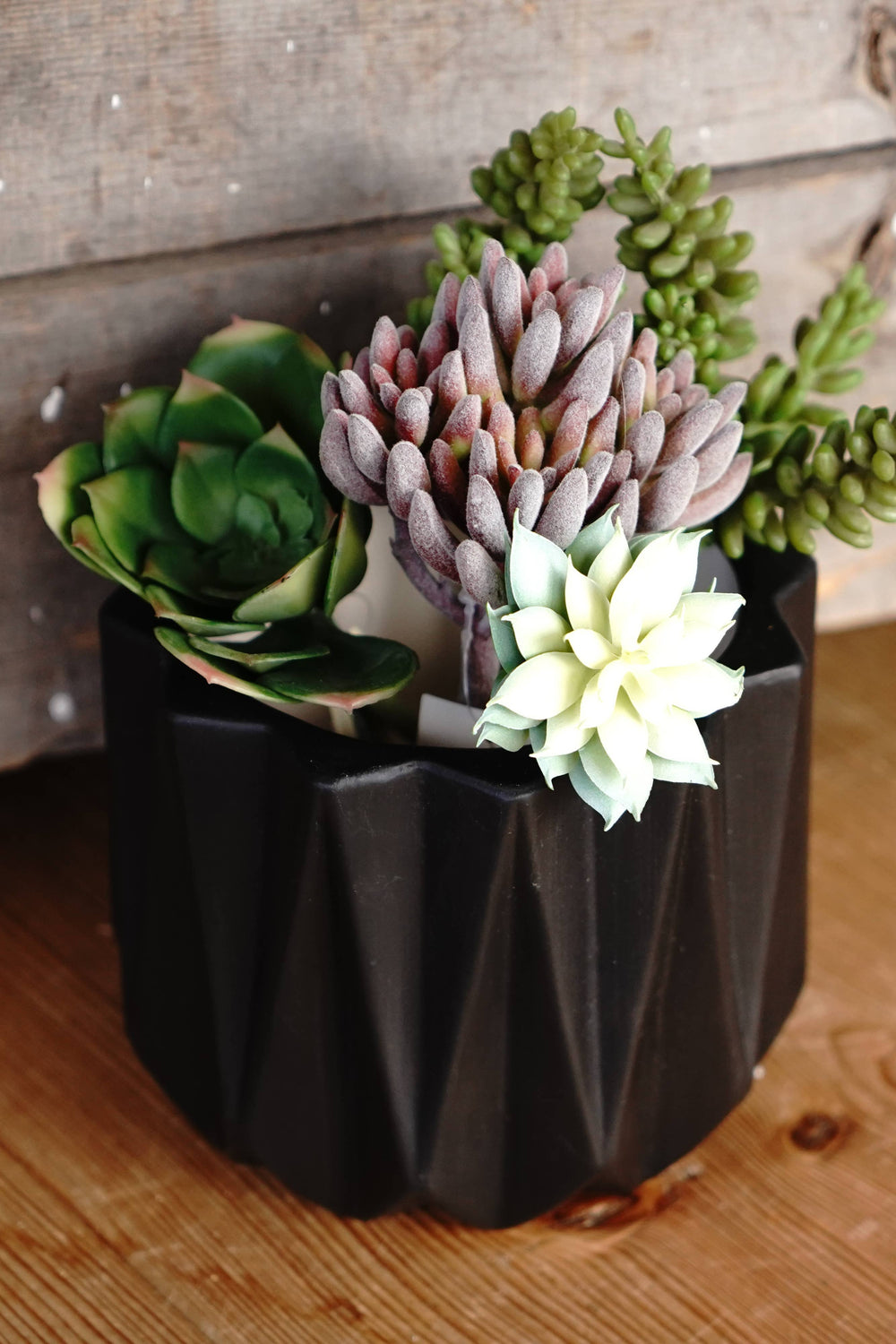 Black geometric planter pot with faux succulents in a matching base holder
