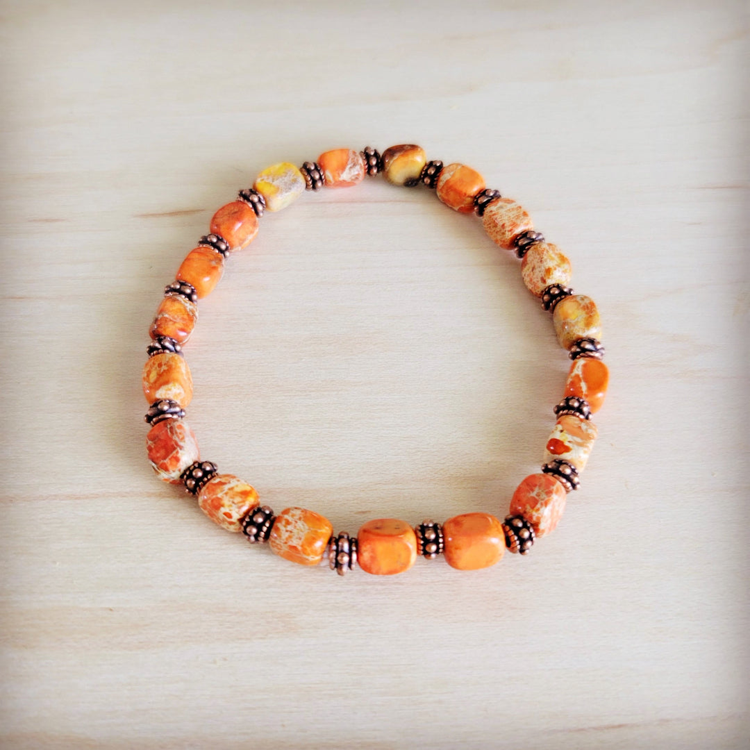 Orange stretch beaded bracelet with faceted beads and dark spacer accents