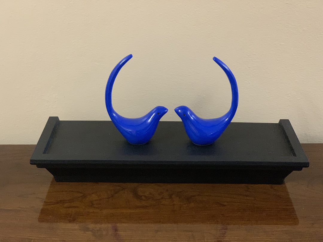 Blue bird figurine pair standing on a black tray