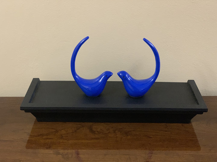 Blue bird figurine pair standing on a black tray