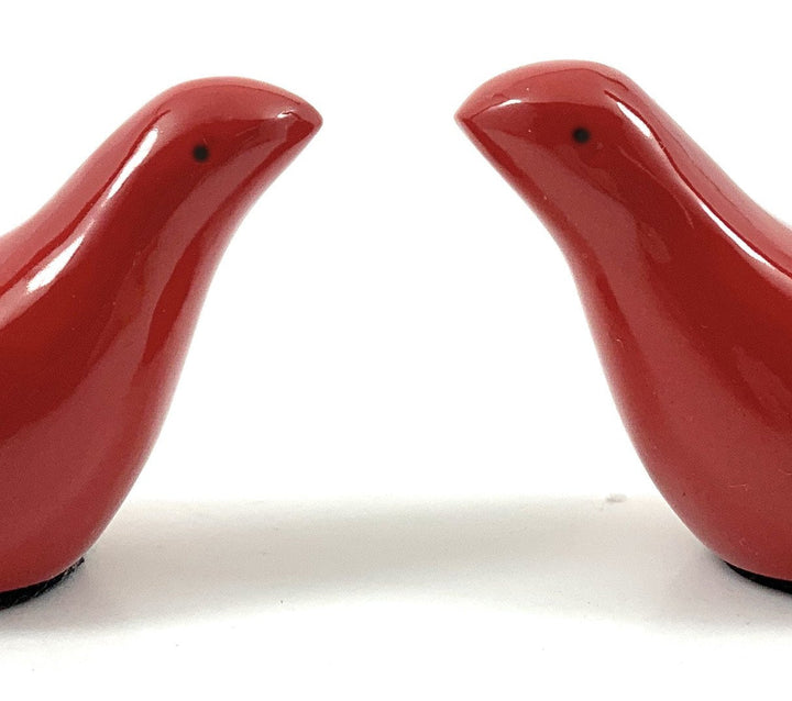 Close-up of two red bird figurines, glossy surfaces with small eye details