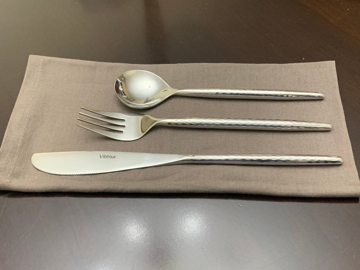 Vibhsa stainless steel cutlery set: spoon, fork, and knife on a napkin