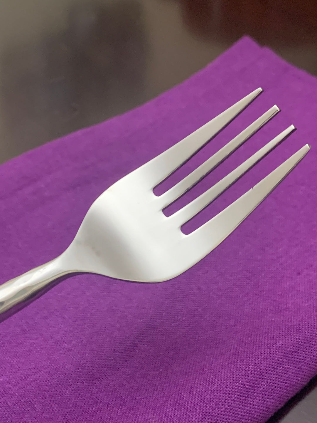 Vibhsa stainless steel dinner fork with hammered handle on a folded napkin