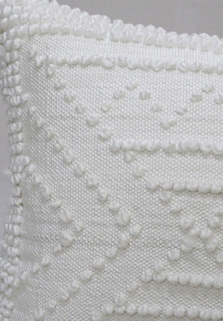 White textured outdoor pillow cover close-up with raised diamond and wave pattern