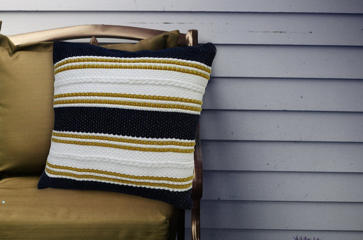 18x18 indoor/outdoor striped pillow with braided trim, navy, white, and gold stripes