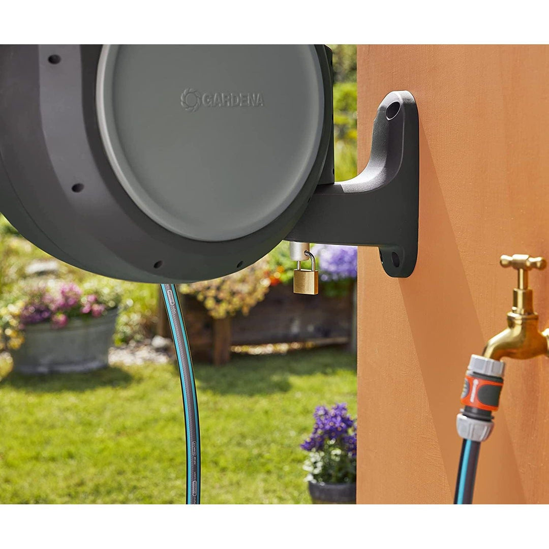 Close-up of wall-mounted hose reel outlet with brass adapter and connected hose