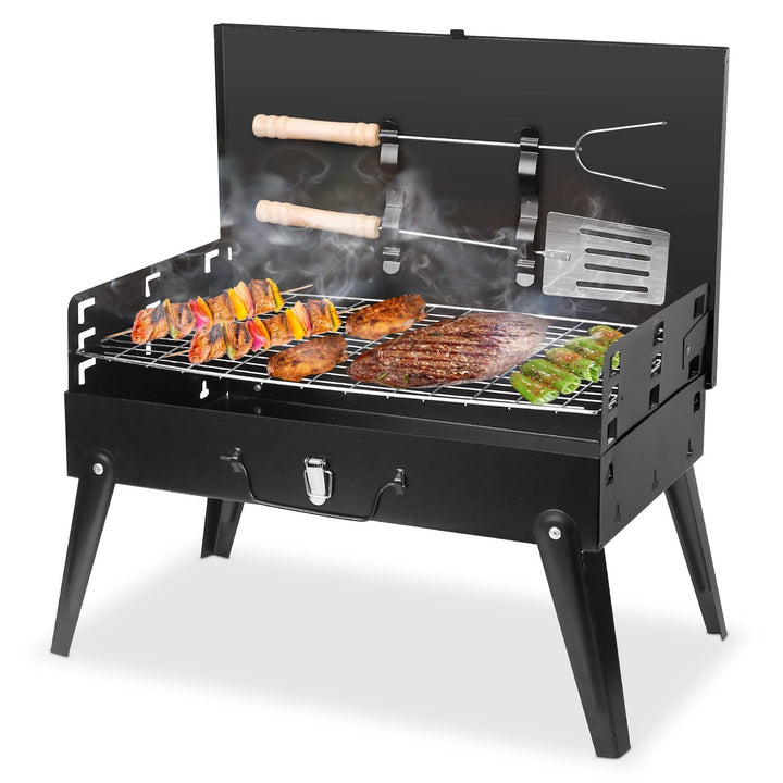 Black foldable charcoal grill with side shelf, cooking grate, and skewers