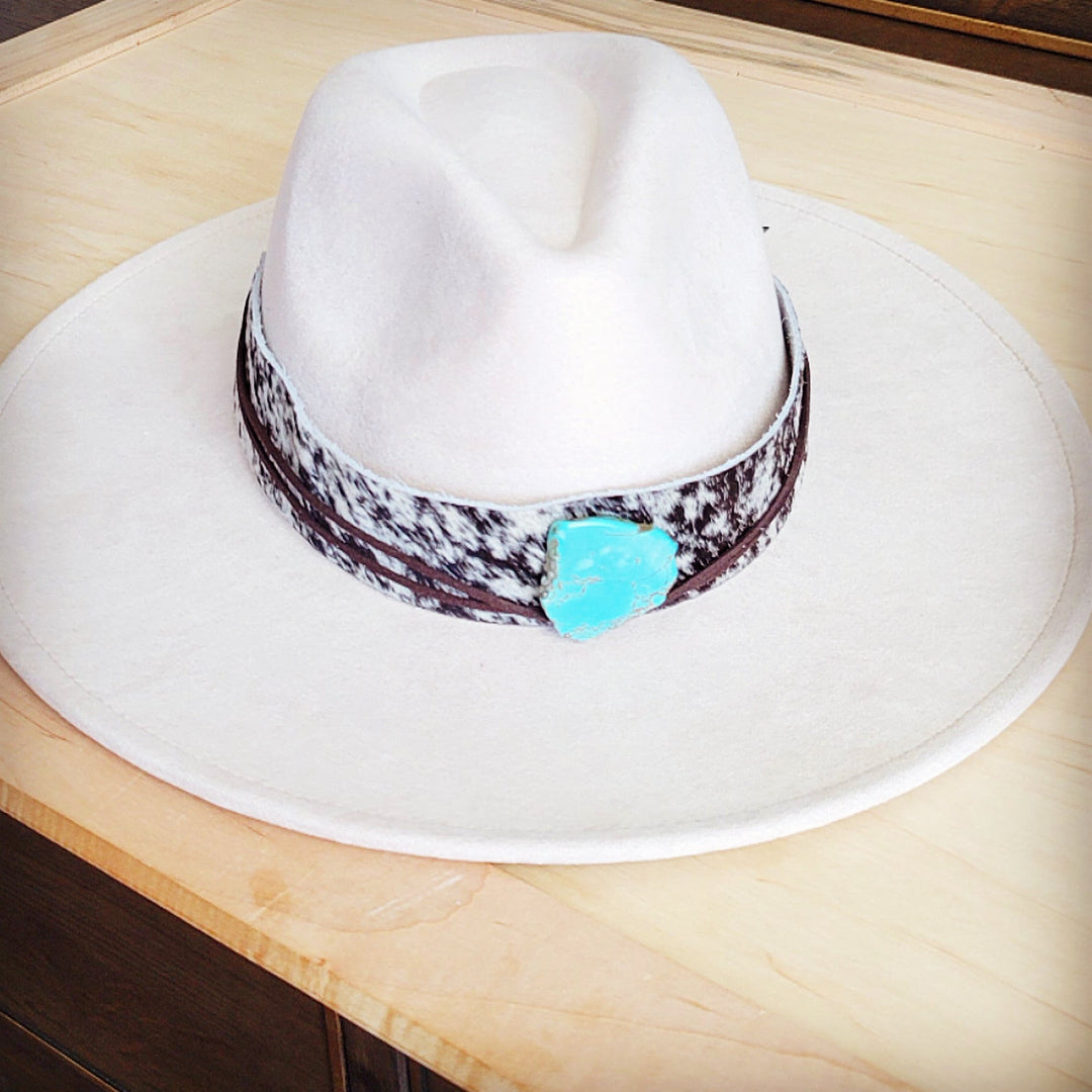 Wide-brim white hat with black spotted leather band and turquoise heart buckle