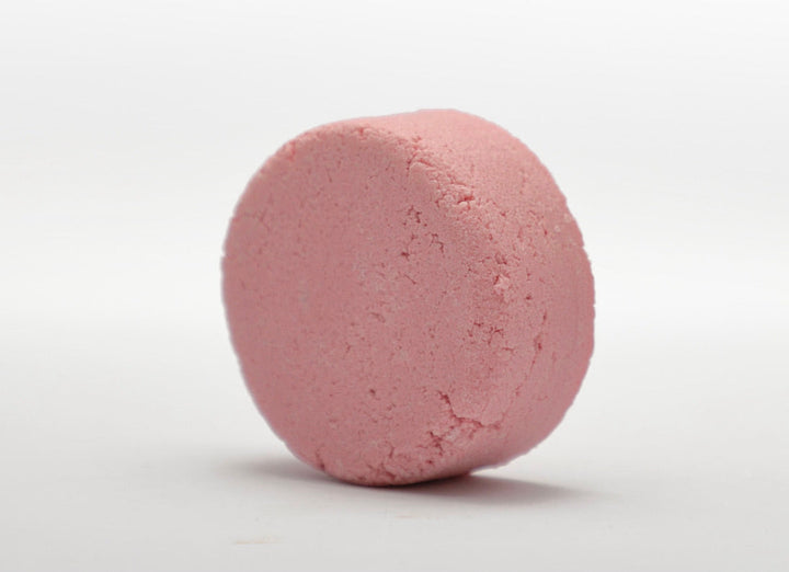 Pink round shampoo bar with textured surface