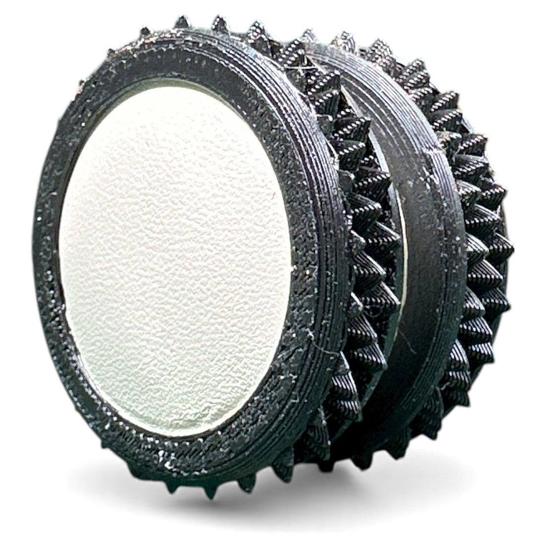 Dark gray fidget moon toy with white oval center and spiky ridged rings