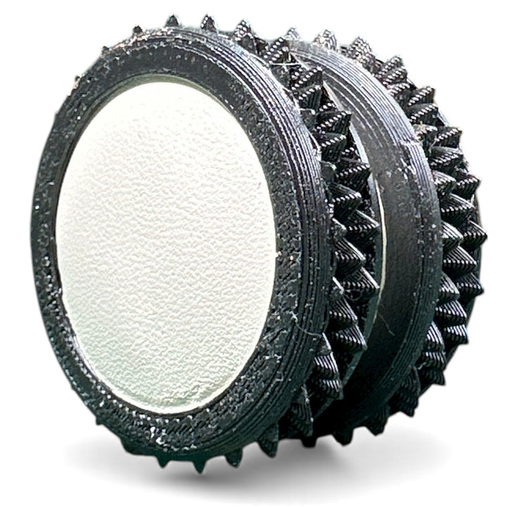 Dark gray fidget moon toy with white oval center and spiky ridged rings