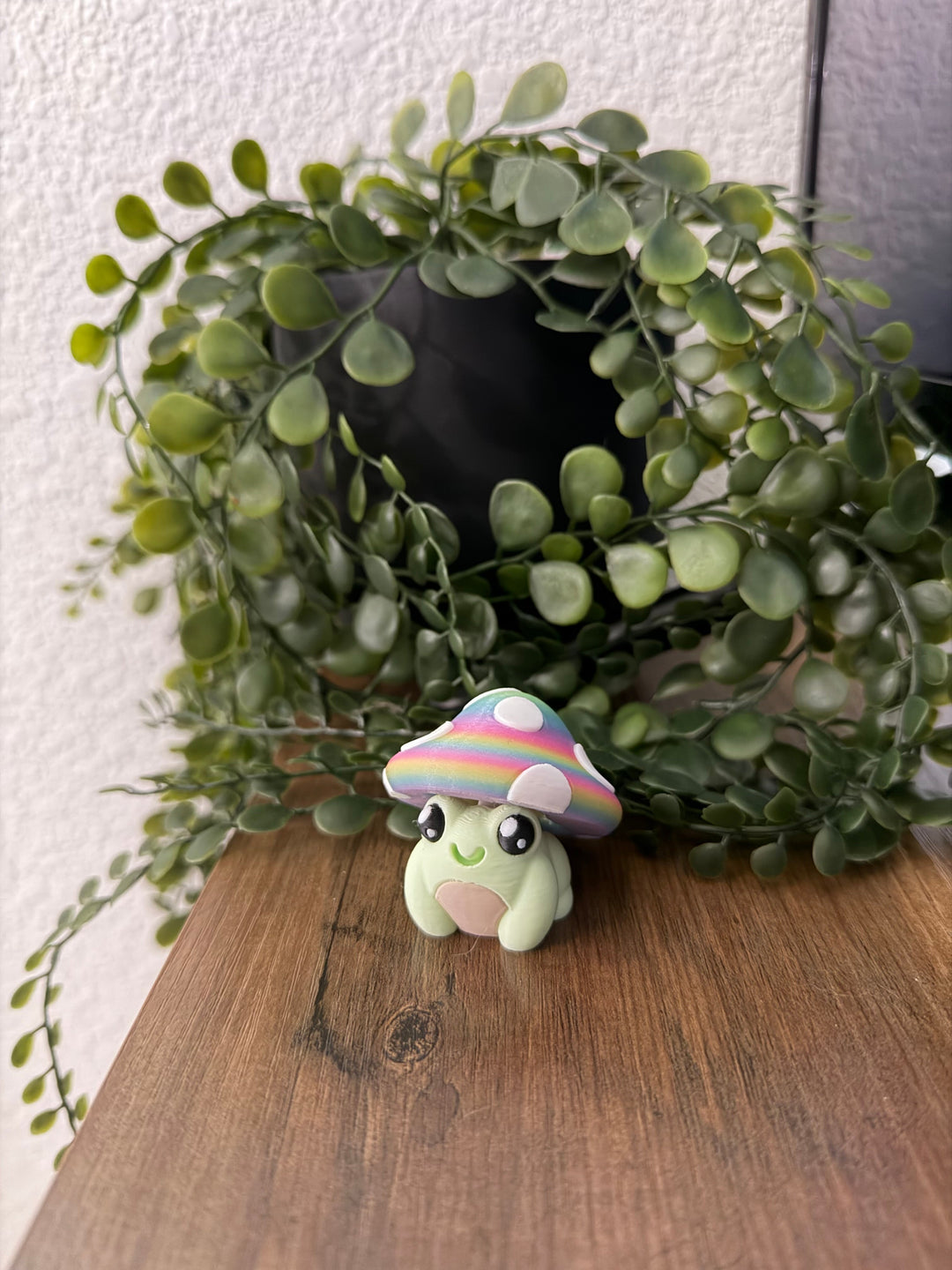 Frog toy with rainbow mushroom cap, smiling face on display