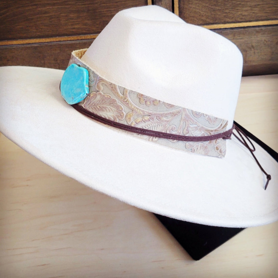 White felt cowboy hat with wide leather band, turquoise centerpiece, side view