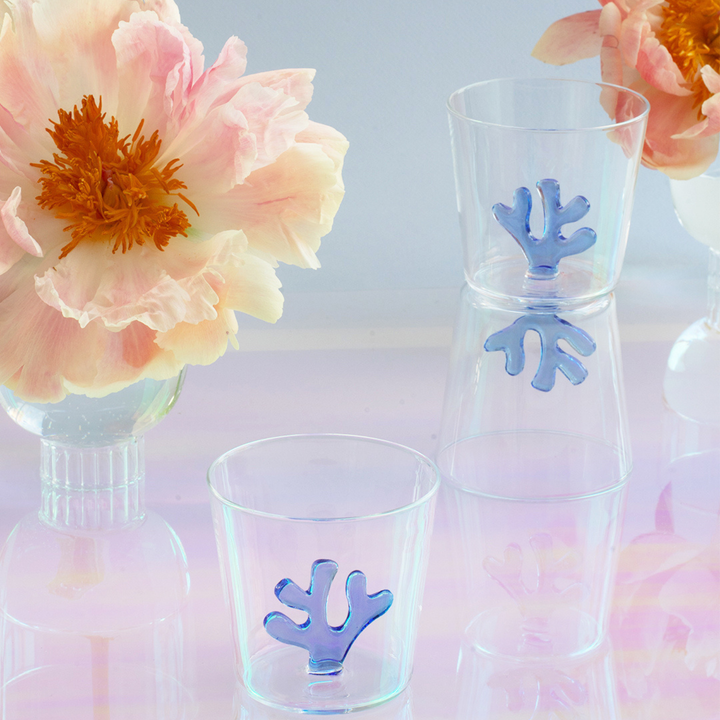 Clear glass water tumbler with blue coral insert, front view