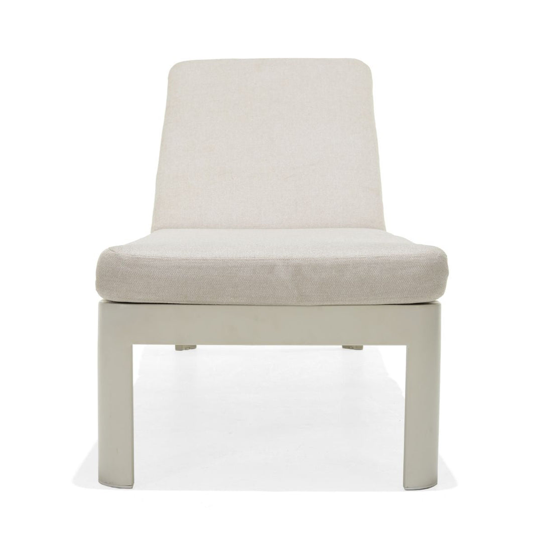 Beige upholstered sun lounger chair with padded seat and back, white frame, four legs