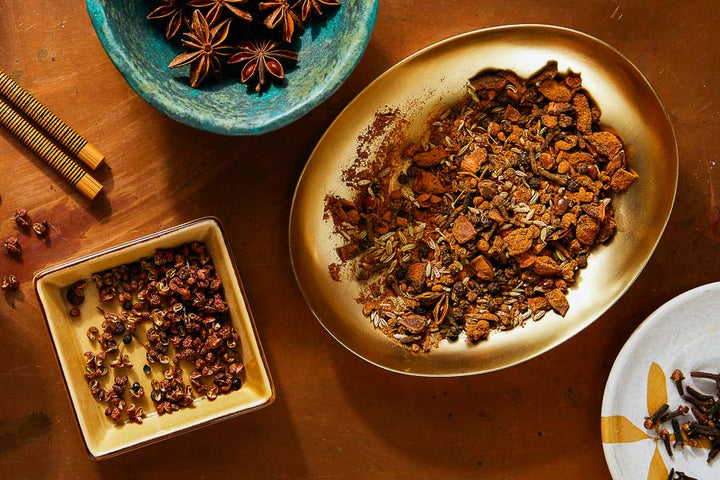 Chinese five-spice seasoning blend in bowl with small tray of spice flakes
