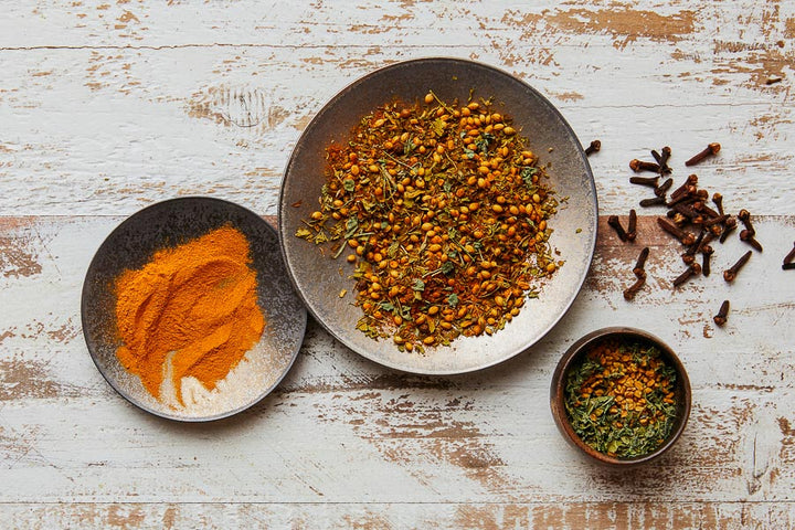 Khmeli Suneli spice blend in a bowl with mixed herbs and seeds