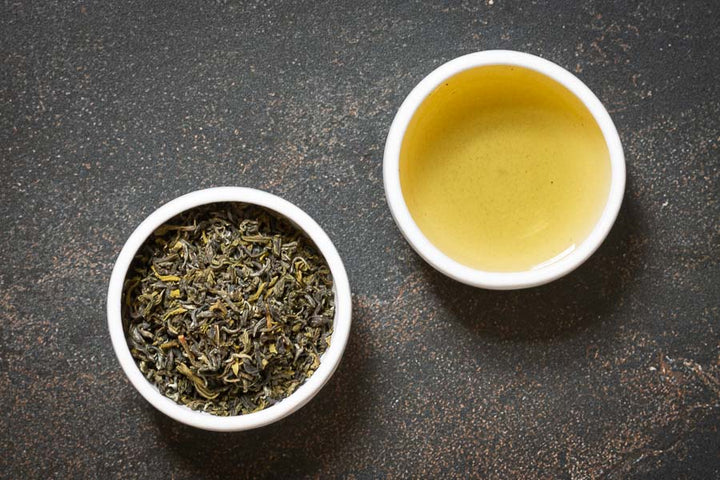 Nepalese green tea leaves with a cup of brewed tea