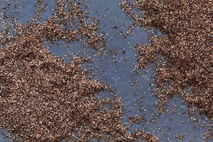 Alderwood smoked salt granules, dark brown-speckled coarse pile