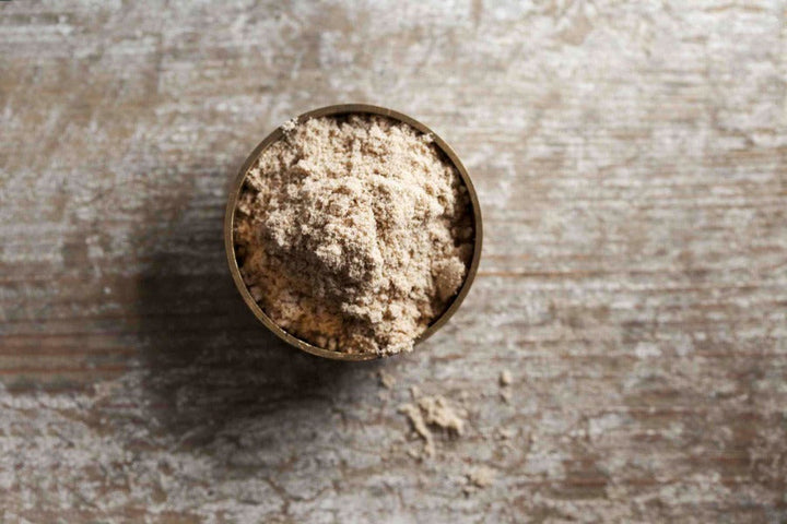 Amchoor mango powder in a small bowl, light beige fine powder