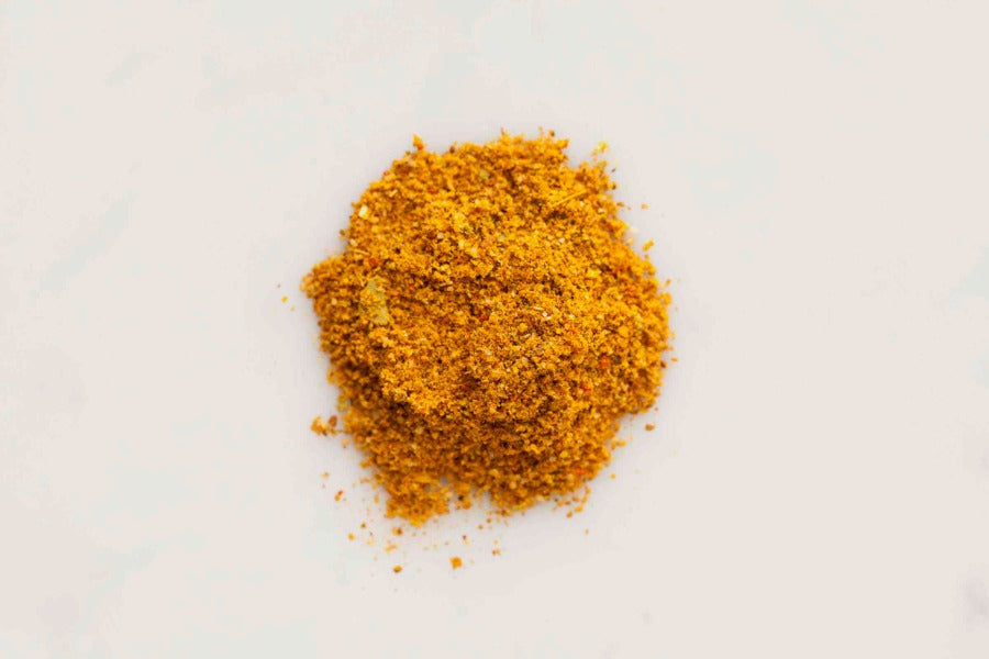 Indonesian ayam seasoning powder mound, finely ground golden-orange spice