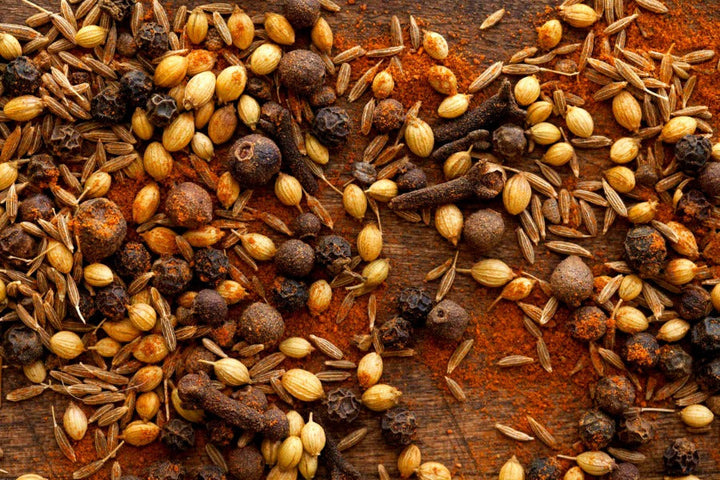Whole spice mixture with grains and ground seeds in warm brown tones