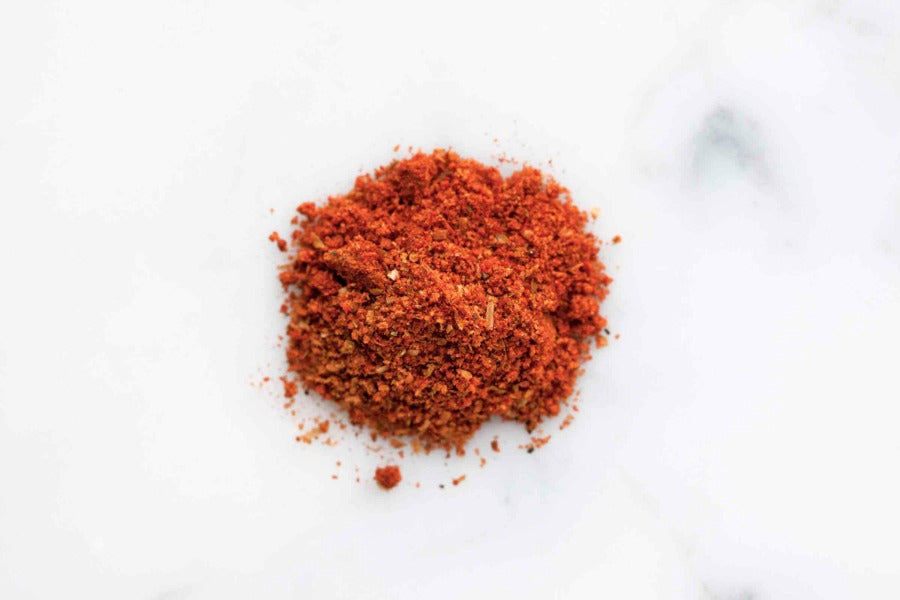 Smoky BBQ rub ground spice pile, deep red powder