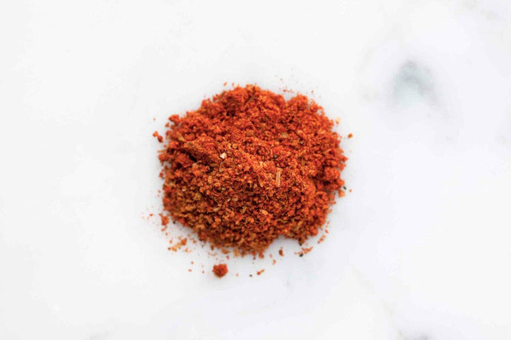 Smoky BBQ rub ground spice pile, deep red powder