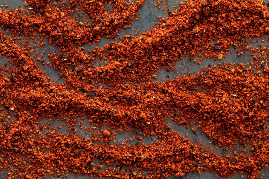 BBQ spice rub with finely ground red-orange seasoning blend spread on surface