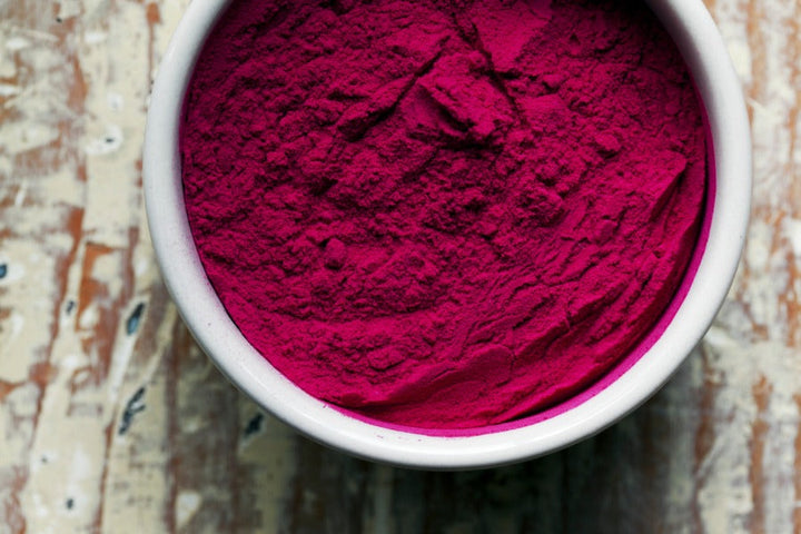 Beet powder: deep magenta fine powder in white bowl