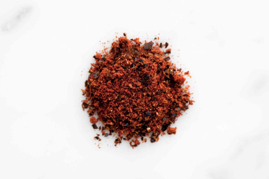 Mound of dark red ground chili powder, ready to season dishes.